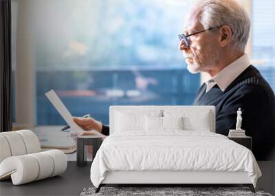 Senior businessman reading a document Wall mural