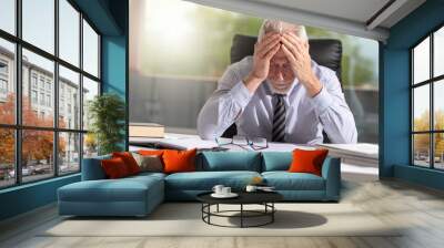 Tired businessman sitting in office Wall mural