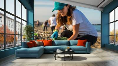 Volunteer woman cleaning beach to protect the environment Wall mural