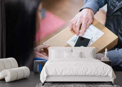 woman receiving package from delivery man Wall mural