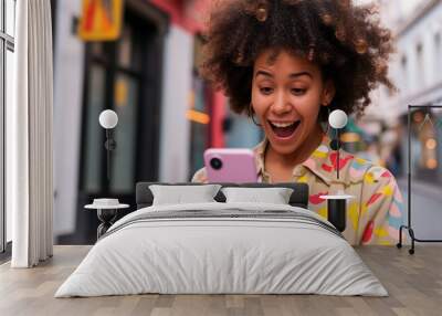 Young woman excitedly looking at smartphone on city street Wall mural