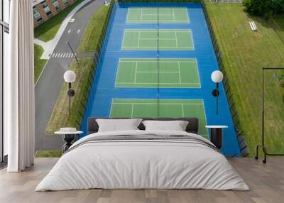 Aerial, drone, photo of new outdoor green tennis courts with white lines and blue out of bounds area.	 Wall mural