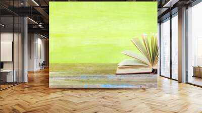 opened book on green grungy background, panoramic, good copy space Wall mural