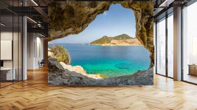 Beautiful sunny view through a rocky cave to the greek blue sea with crystal clear water from an a hill with boats cruising fishing surrounded by mountains, Patmos Island, Kos, Dodecanese/ Greece  Wall mural