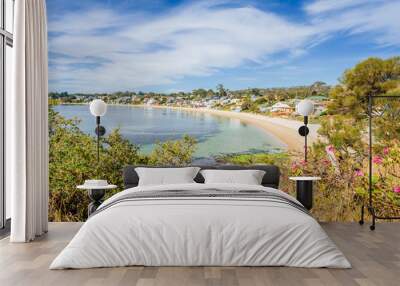 Pretty little to village town view with great paradise sandy beach with turquoise blue water and green covered rocks stone on warm sunny clear day for relaxing Opossum Bay, Hobart, Tasmania, Australia Wall mural