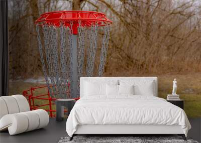 Red disc golf goal, net, pole hole, entrapment basket on a raw winter day.   Wall mural