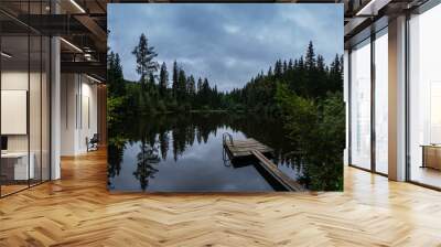 wooden jetty with railing on a clear mountain lake and reflection panorama Wall mural