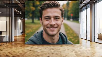 Close portrait of a smiling young Canadian man looking at the camera, Canadian outdoors blurred background Wall mural