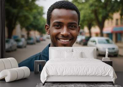 Close portrait of a smiling young Somali man looking at the camera, Somali outdoors blurred background Wall mural