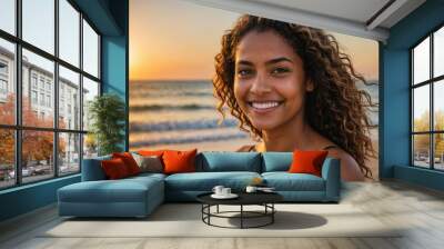 Portrait of a smiling young beautiful brasilian woman  on the beach at sunset Wall mural