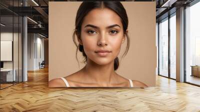 Portrait of young beautiful latin woman with perfect smooth skin over beige background. Wall mural