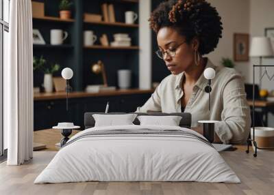 Side view of African American busy woman in casual wear writing in stylish organizer with white pages Wall mural