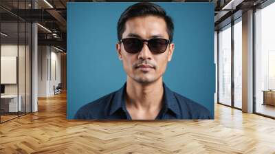 travel asian man wearing dark sunglasses  portrait, isolated on blue background Wall mural