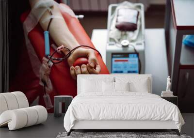 The hand of a man who donates blood. Male donor gives blood in a blood donation center Wall mural