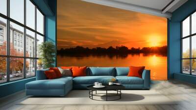 Beautiful sunset on the river bank./The sun is setting on the banks of the river. Create a beautiful natural light. Wall mural