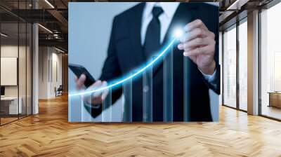 Businessman looking at data on mobile phone and pointing arrow graph at top to indicate success in business development. Business growth concept, future corporate growth, online business. Wall mural