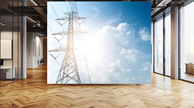 high-voltage tower standing under the blue sky and light shining behind it. Wall mural