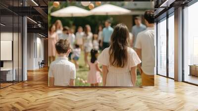 A gathering of people in a sunny garden, enjoying a festive event with children and adults, dressed in light, casual clothing. Wall mural