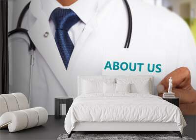 About us text on card held by physician. Wall mural