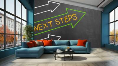 next steps concept with chalk text and arrows on blackboard. Wall mural