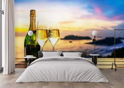 Champagne bottle on a beach table with two champagne glasses at sunset, perfect for a summer couple. Wall mural