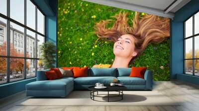 Appreciating the beauty of life. High angle shot of a carefree young woman relaxing in a field of grass and flowers. Wall mural