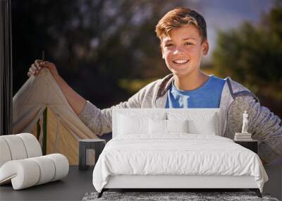 Camping is the best. Shot of a young boy putting up his tent on a camping trip. Wall mural