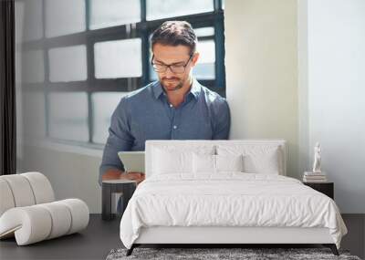 Hes a tech-savvy businessman. Cropped shot of a businessman working on his tablet in the office. Wall mural