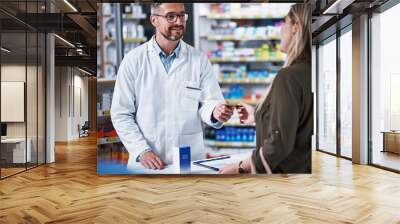 Yes, we do accept cards here. Shot of a young woman paying for merchandise with a credit card at a pharmacy. Wall mural