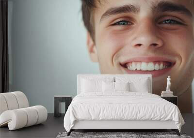 Young man with clean-shaven face, soft smile, and bright eyes, exuding positivity and friendliness, isolated on white Wall mural