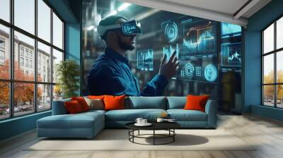 A man wearing VR headset interacts with a futuristic interface displaying data visualizations in a factory setting. Wall mural