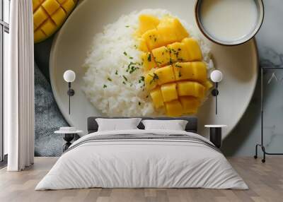 Closeup of a bowl of sticky rice topped with mango slices and a small bowl of coconut milk. Wall mural