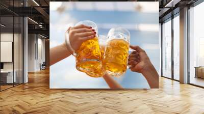 Raised beer mug toasting at Oktoberfest Wall mural