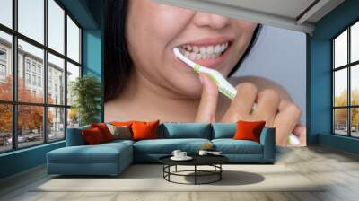 Asian woman brushing her teeth dental care concept Daily routine after bathing brush your teeth with a toothbrush Clean your mouth in the morning and evening. oral hygiene and care Wall mural