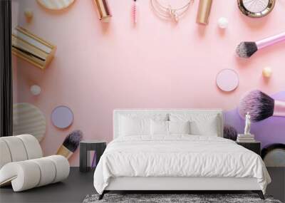 Makeup brushes, sponges and decorative cosmetics on purple and pink colored background. Top view, copy space Wall mural