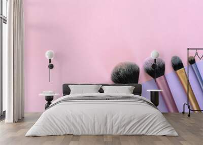 Makeup brushes on purple and pink colored background. Top view, copy space Wall mural