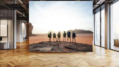 Tourist friends on a top of mountains in a desert. Sunset view. Nature. Tourist people enjoy a moment in a nature. Wadi rum national park - Jordan  Wall mural