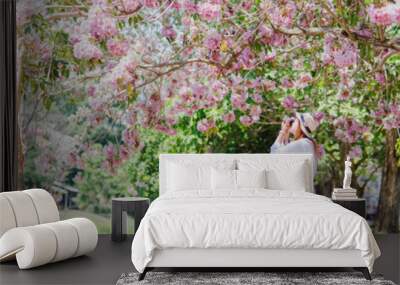 spring season with full bloom pink flower travel concept from beauty asian photographer woman enjoy with sight seeing and take photo  sakura or cherry blossom with soft focus flower background Wall mural