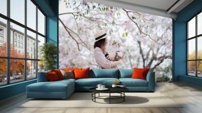 the springtime brings asian woman and her cat on a journey Wall mural