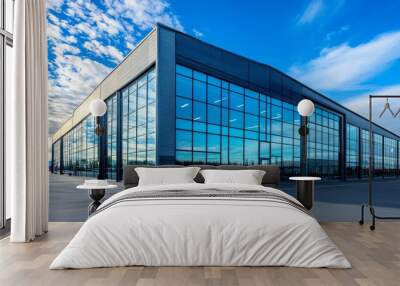 A sleek and modern office building with a glass facade, showcasing a professional and innovative workspace. The building is set against a backdrop of a bright blue sky with white clouds, symbolizing g Wall mural