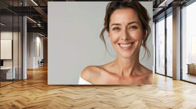 Portrait of a smiling brunette woman - A close-up portrait of an attractive brunette woman with a warm smile, radiating confidence and happiness Wall mural