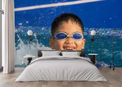 Cute little boy with his goggles on in swimming pool Wall mural