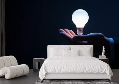 A glowing light bulb in a businessman's hand with place for text Wall mural