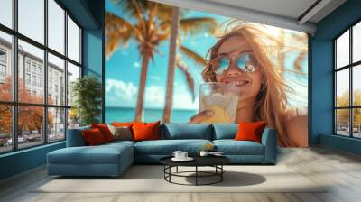 Portrait of a happy girl in sunglasses with a cocktail against the backdrop of a beautiful golden sunny beach with palm trees and the blue ocean. AI generative Wall mural