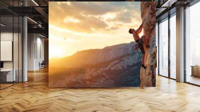 Young man climbing a rock against the backdrop of a beautiful su Wall mural