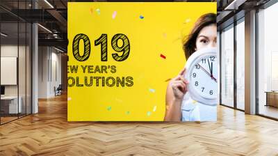 2019 New Years Resolutions with young woman holding a clock showing nearly 12 Wall mural