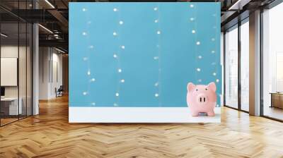 A piggy bank saving and investment theme on a shiny light blue background Wall mural