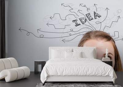 Brainstorming idea arrows with young woman looking upwards on a gray background Wall mural