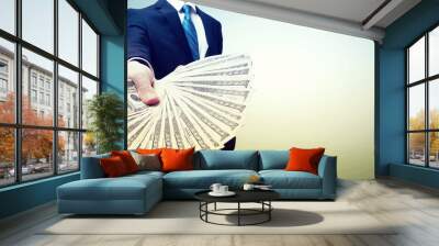 Business man displaying a spread of cash Wall mural