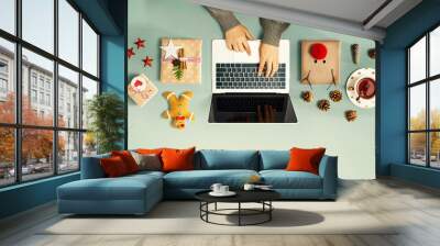 Christmas giftboxes with person using a laptop computer - overhead view Wall mural